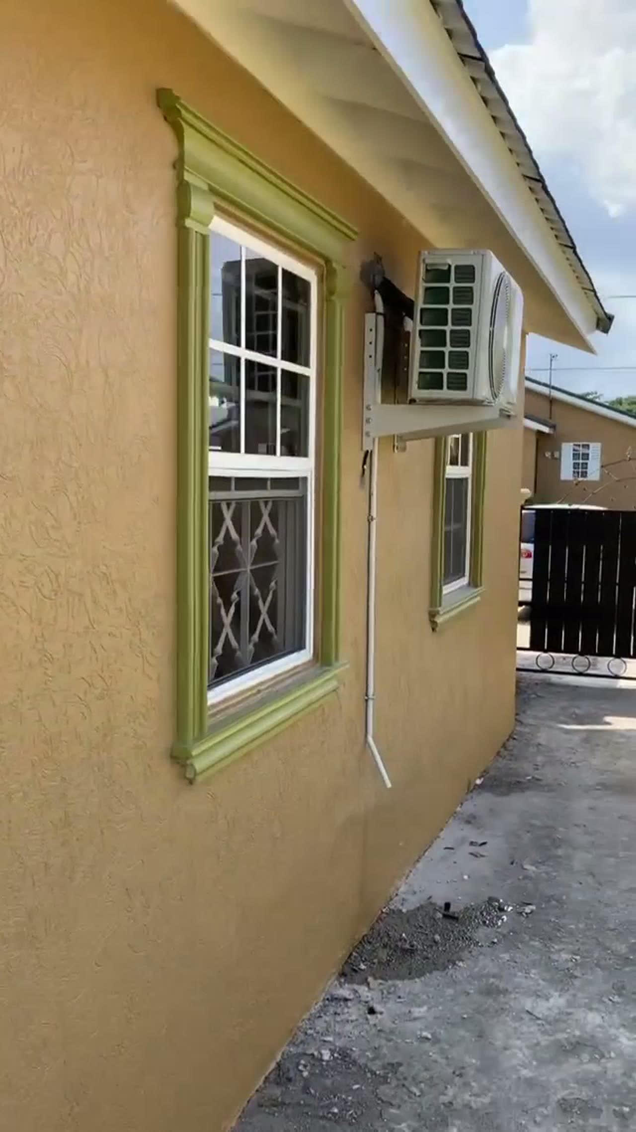 Krispy Kool outdoor AC installation on a Jamaican wall